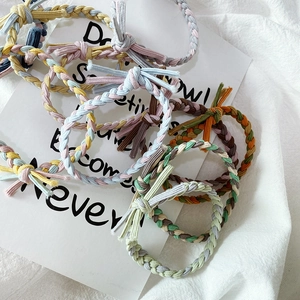 Close-up of hand-woven braided hair ties in various contrast colors with knot detail