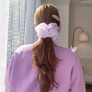 Detail eines übergroßen lila Organza-Haargummis mit Falten an einem Pferdeschwanz