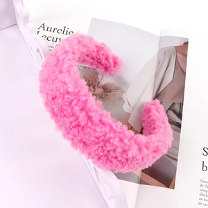 Close-up of bright pink lamb wool headband with thick teddy fleece texture for women