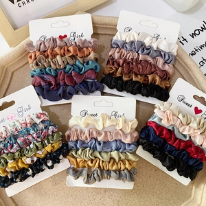 Detail of colorful satin scrunchies sets on elegant display cards for hair styling