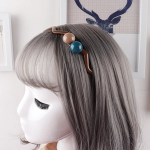 Nahaufnahme eines minimalistischen welligen Stirnbands mit Perlen auf grauem Haar