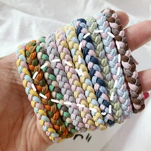 Close-up of hand-woven elastic hair ties in various Morandi colors and braided texture
