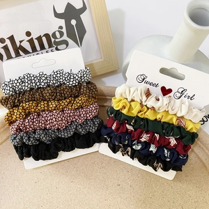 Detail of 12-piece satin scrunchie set in floral and solid colors on display card