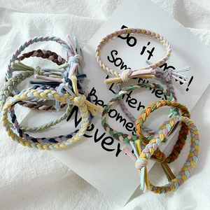 Close-up of handmade braided colorful elastic hair ties in various vibrant color schemes