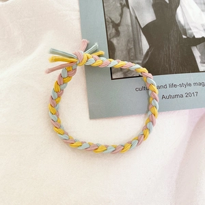 Detail of pink, yellow, and blue braided hair tie with a decorative knot detail