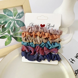 Close-up of 6-piece colorful satin scrunchies set on premium display card