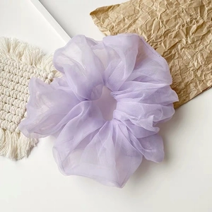 Detail eines hellvioletten Organza-Haargummis mit zarter, plissierter Netzgewebestruktur
