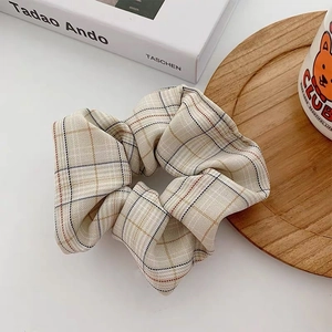 Plaid pattern fabric scrunchie in beige with minimalist grid design and fabric texture