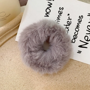 Close-up of soft grey faux rabbit fur scrunchie with fluffy texture and elastic band