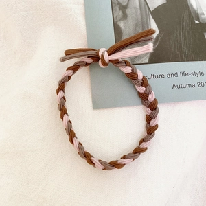Detailed view of hand-woven braided hair tie in brown, pink, and taupe color mix