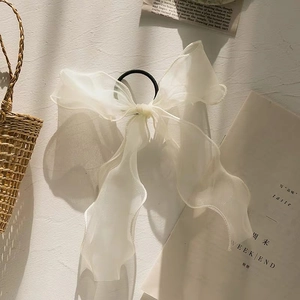 Detail of elegant white organza bow scrunchie with high elasticity black hair rope