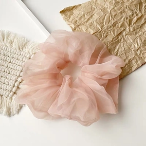 Detailansicht der rosa Organza-Haargummi-Textur auf strukturiertem Hintergrund