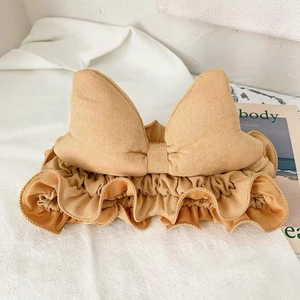 Detail of caramel bow headband featuring soft velvet fabric and elastic pleated design