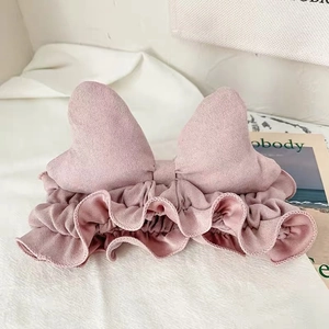 Close-up of pink flannel bow headband with ruffle trim for facial cleansing and skincare