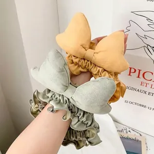 Set of two bow headbands in ginger and bean green with soft suede texture and frill edges