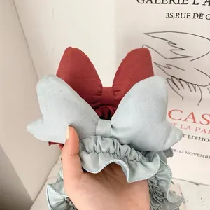 Chic oversized bow headbands in red and blue textured fabric for facial washing
