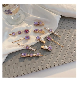 Detailed macro view of purple gemstone and pearl hairpins on gold metal setting