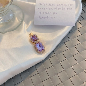 Detail of vintage purple gemstone hair clip with golden setting and white rhinestones