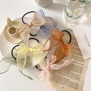 Vue détaillée de chouchous nœuds en organza coloré en six tons pastel posés sur un plateau