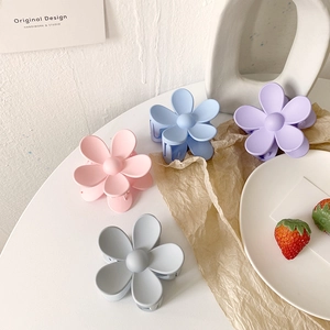 Detailansicht der matten Blumen-Haarklammern in Pastellrosa, Blau, Lila und Grau