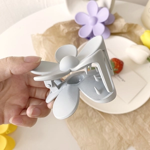 Nahaufnahme einer mattblauen Blumen-Haarklammer mit einem 3D-Fünf-Blütenblatt-Design