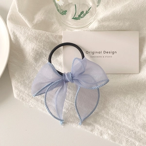 Détail d'un chouchou noeud en organza lilas avec coutures délicates et bande élastique