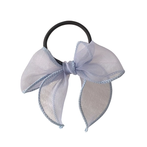Chouchou élégant en organza bleu clair avec double nœud sur fond blanc impeccable