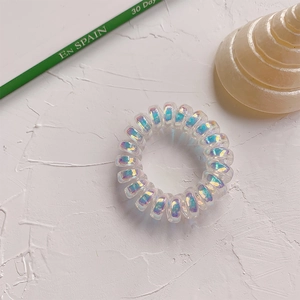 Gros plan sur des élastiques spirales irisés avec texture transparente et reflets nacrés