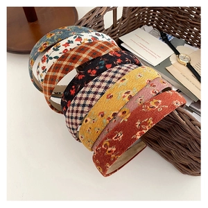 Set aus Retro-Haarreifen mit Blumenmuster und Karos in einem geflochtenen Korb präsentiert