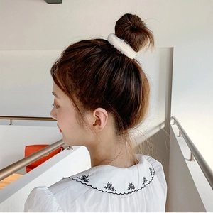 Chouchou blanc en fausse fourrure de vison porté sur un chignon pour un style rétro français