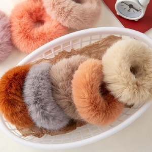 Detail of plush faux fur scrunchies in pastel colors arranged in a storage basket