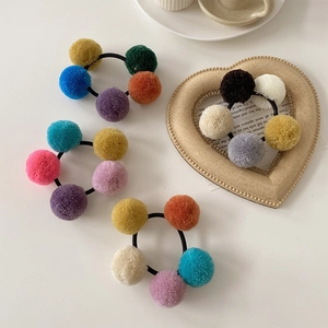 Macro detail of colorful faux fur pompom hair ties with high elasticity rubber bands