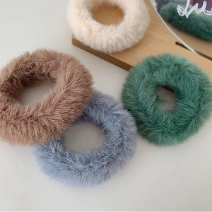 Gros plan de quatre chouchous en fausse fourrure en beige, marron, bleu et vert
