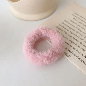Gros plan d'un chouchou en fausse fourrure rose avec texture moelleuse et élastique
