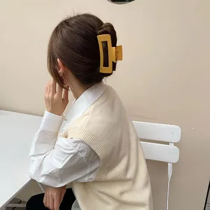 Matte yellow rectangular hair claw clip shown in a side view on model's hair