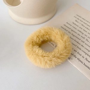 Gros plan d'un chouchou en fausse fourrure jaune pâle doux pour les styles d'hiver