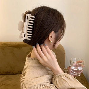 Elegant large matte white hair claw clip for thick hair styling in warm home setting