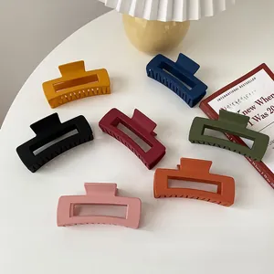 Detail of matte rectangular hair claws in various Morandi colors on a white table