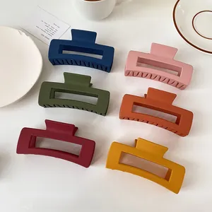 Set of six large matte rectangle hair claw clips in elegant Morandi colors on white table