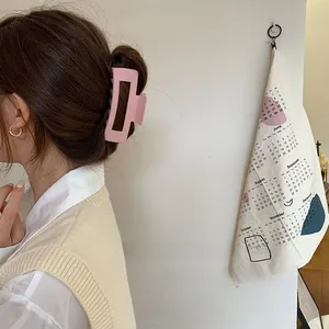Pink matte rectangular claw clip shown on hair for a Korean style elegant hairstyle