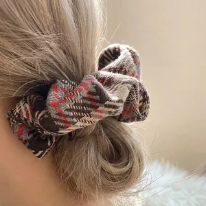 Vintage houndstooth thick fabric scrunchie with elegant brown tweed texture for ponytail