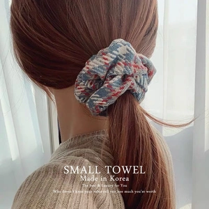 Close-up of vintage plaid plush scrunchie in red and blue on a low ponytail