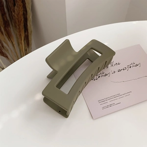 Detail shot of large rectangular matte olive green hair claw clip for elegant styling