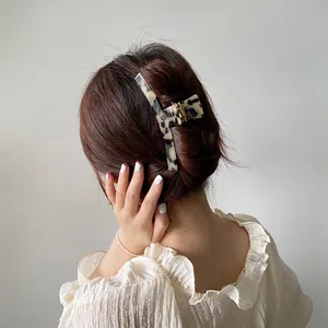 Large tortoiseshell hair claw clip for elegant updo hairstyles on a female model