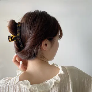 Detail of elegant large tortoise shell hair claw clip styled on woman's head
