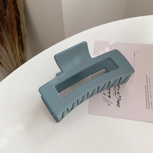 Close-up of matte blue rectangular hair claw clip for elegant long hair styling