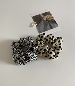 Detailed macro view of leopard print and polka dot fabric scrunchies with soft texture