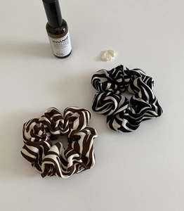 Close-up of zebra pattern fabric scrunchies with fine ribbed texture on white surface