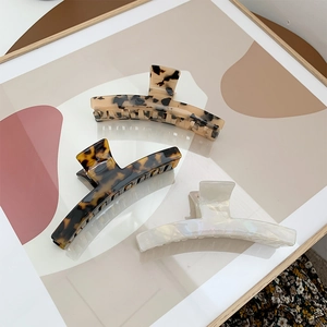 Three elegant acetate shark hair claw clips in tortoise shell and pearlescent white finish