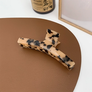 Macro shot of large tortoise shell acetate hair claw clip with elegant leopard pattern